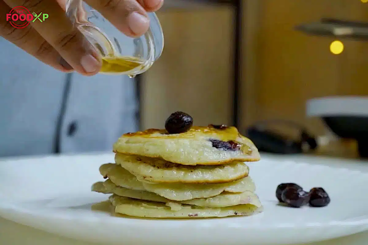 Honey drizzling over Gordon Ramsay Blueberry Pancakes